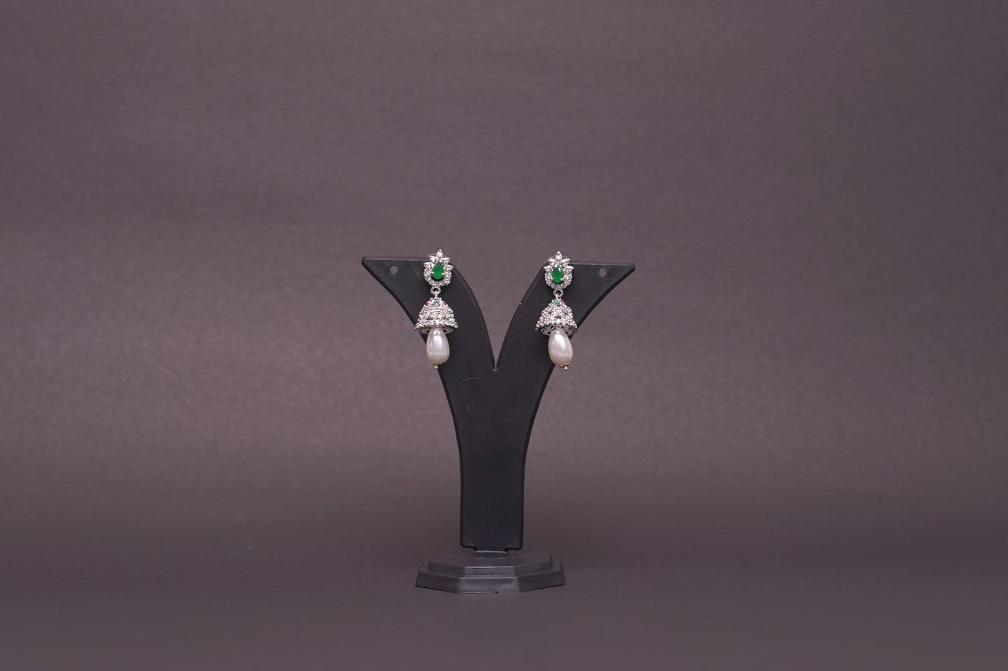 Jhumkas in American diamond adorned with pearls and green, emerald stones