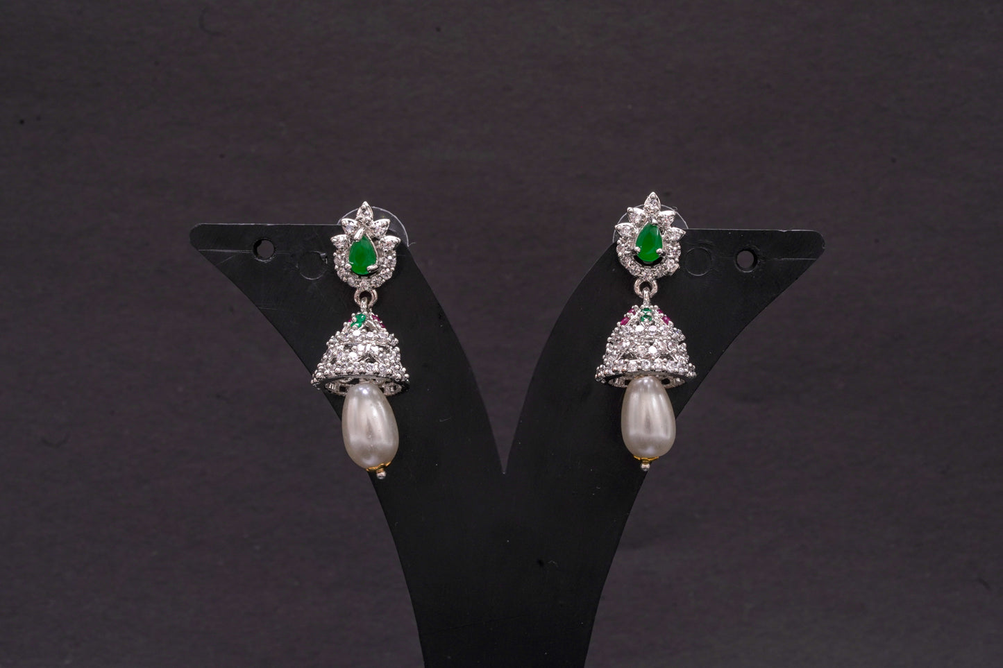Jhumkas in American diamond adorned with pearls and green, emerald stones