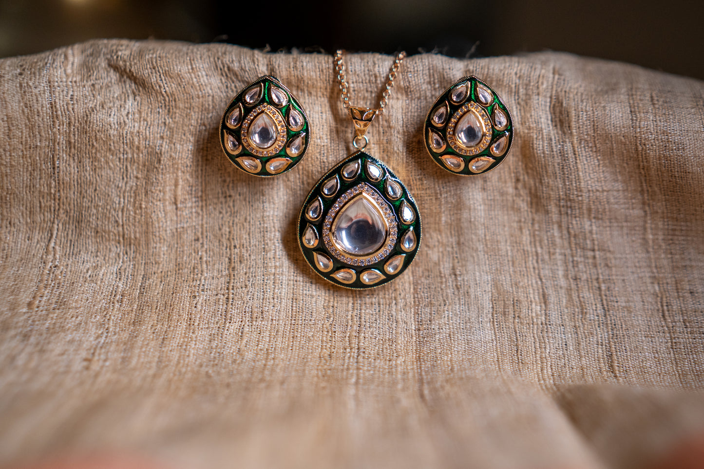 Luminous pendant set with dark green enamel and glittering stone polki
