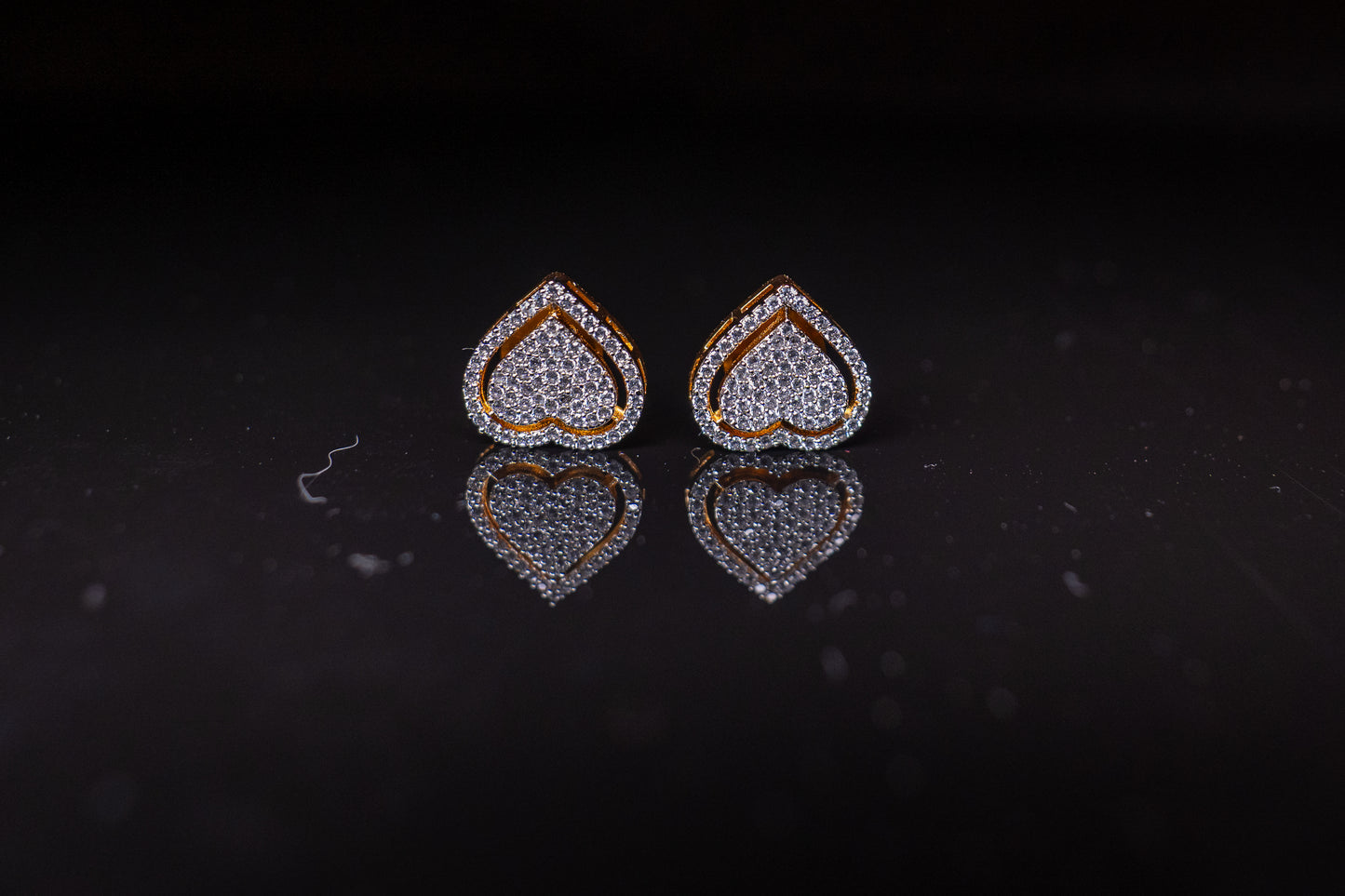 Delicate heart shaped ear studs in American diamond in gold finish