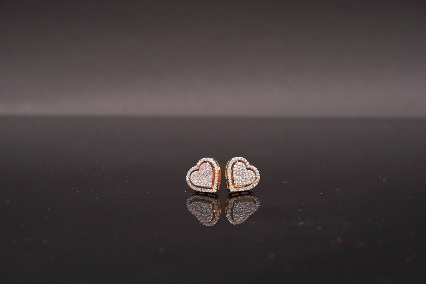 Delicate heart shaped ear studs in American diamond in gold finish
