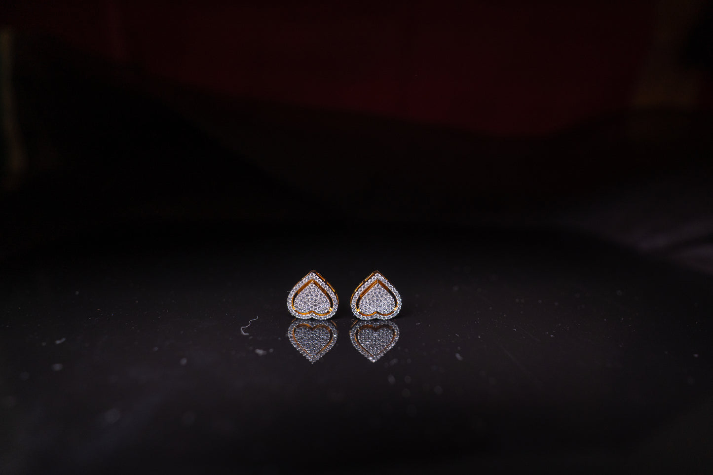 Delicate heart shaped ear studs in American diamond in gold finish