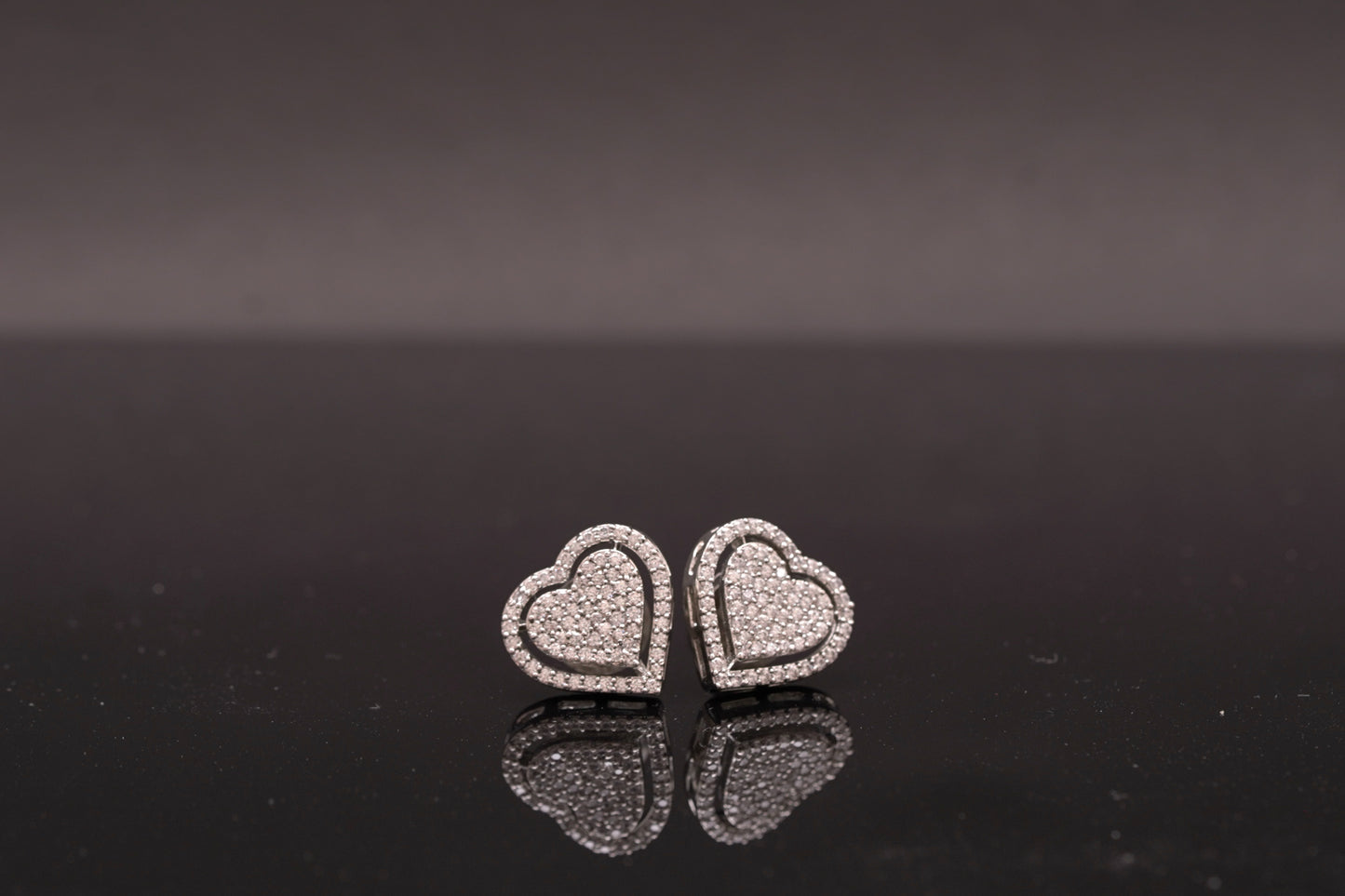Delicate heart shaped ear studs in American diamond in white gold finish