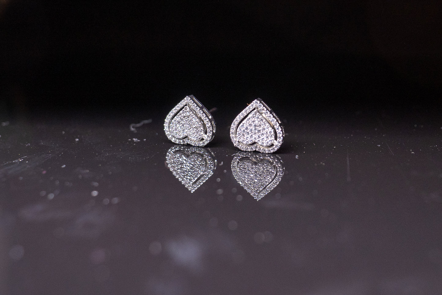 Delicate heart shaped ear studs in American diamond in white gold finish