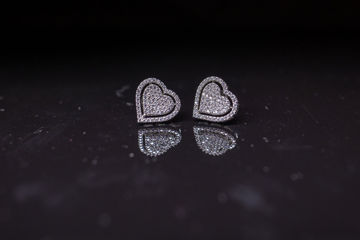 Delicate heart shaped ear studs in American diamond in white gold finish
