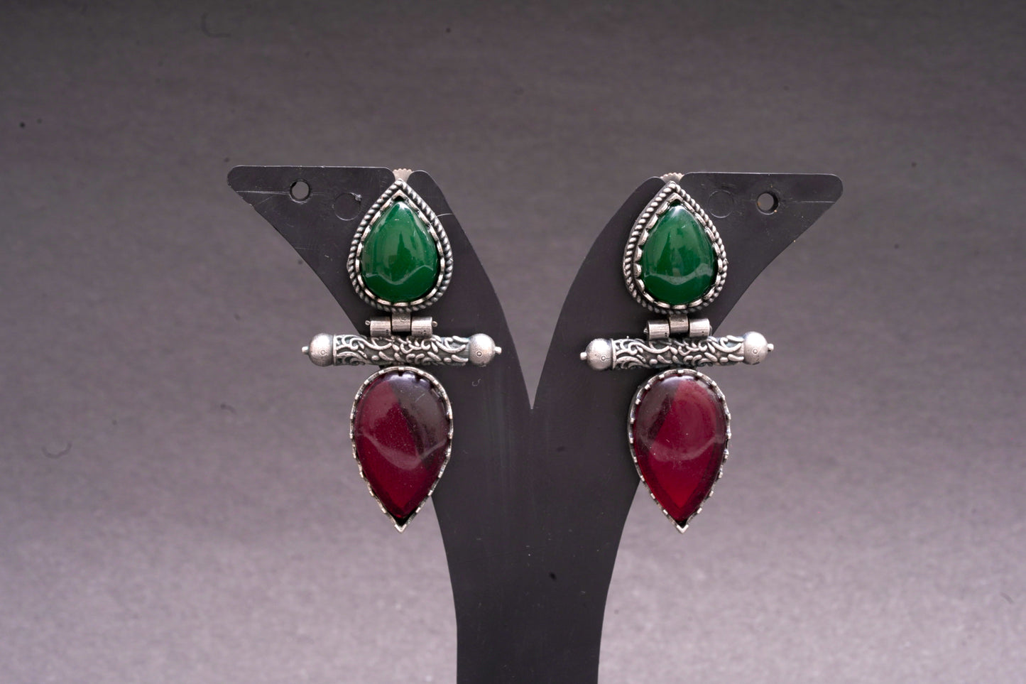 Dual tear drop earrings with red and green stone in silver finish