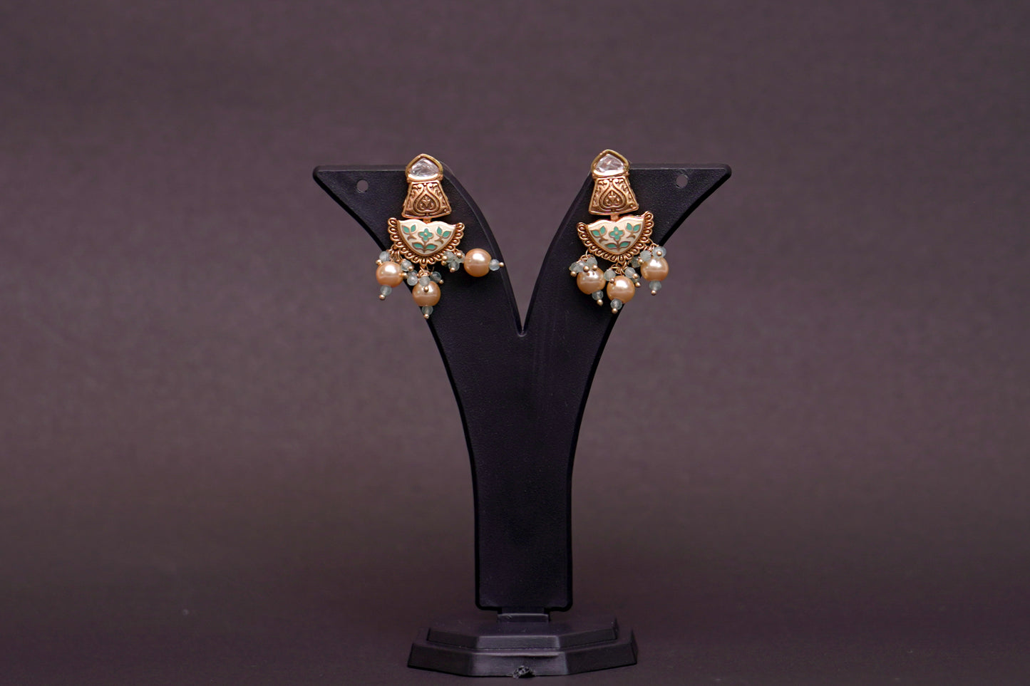 Earrings with white and green enamel work in gold finish