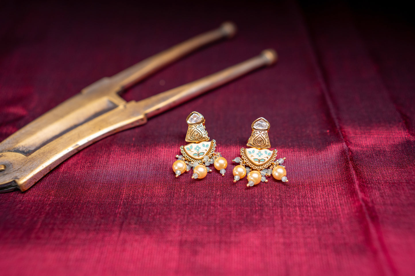 Earrings with white and green enamel work in gold finish