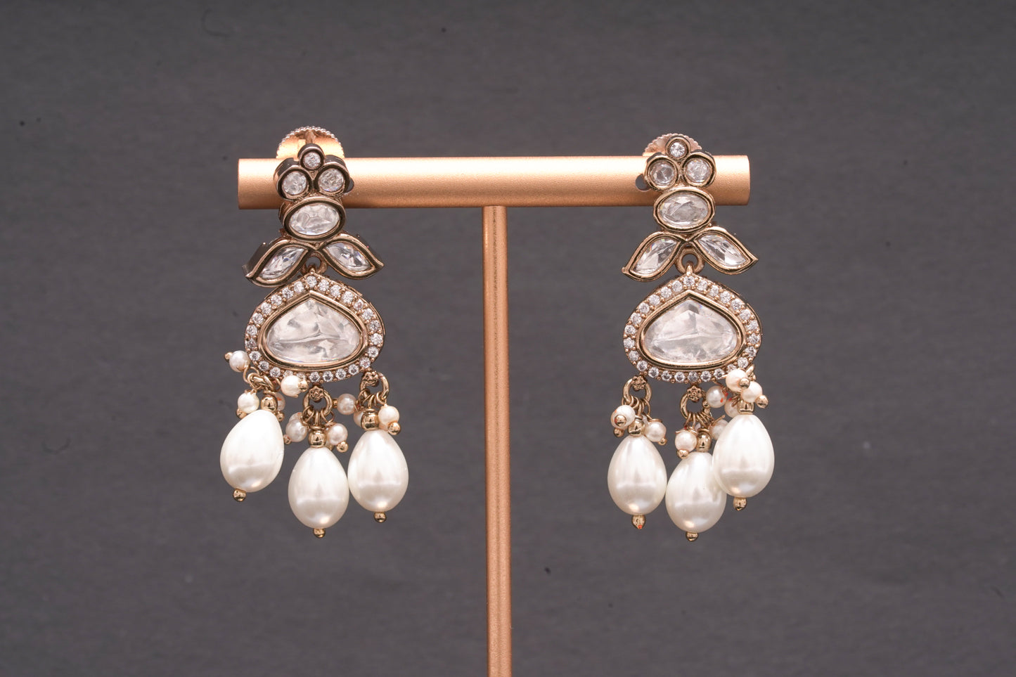 Chandelier earrings with stone polkis and dual sized pearls in a gold finish