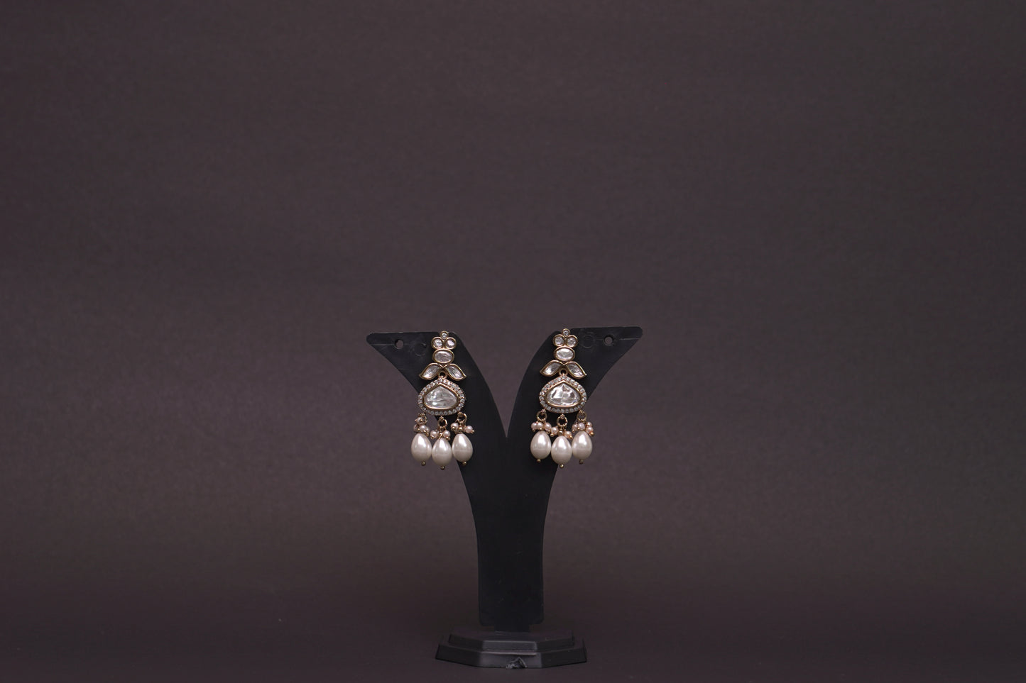 Chandelier earrings with stone polkis and dual sized pearls in a gold finish