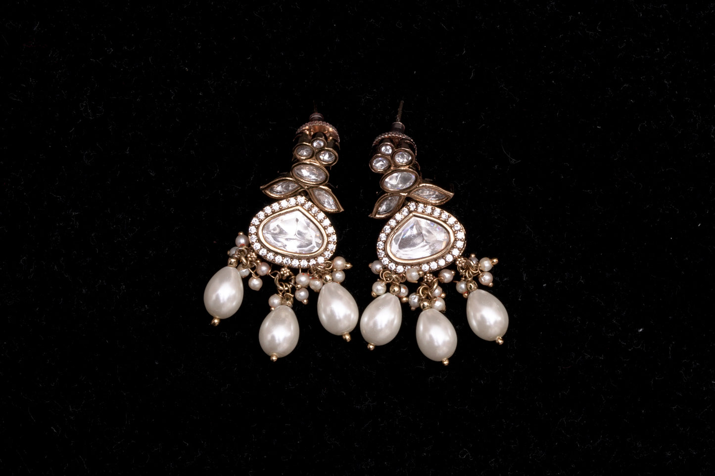 Chandelier earrings with stone polkis and dual sized pearls in a gold finish