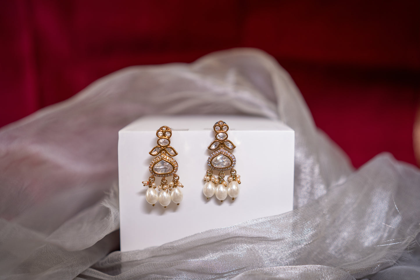 Chandelier earrings with stone polkis and dual sized pearls in a gold finish